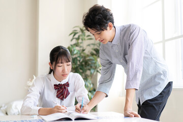 Obraz premium 家庭教師に勉強を教わる学生
