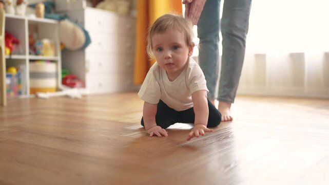 baby crawls. happy family a kid dream concept. baby crawls takes first steps to study indoors. mother teaches baby to crawl takes first steps. lifestyle children learning concept