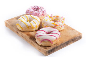 Sweet glazed donuts on cutting board isolated on white background