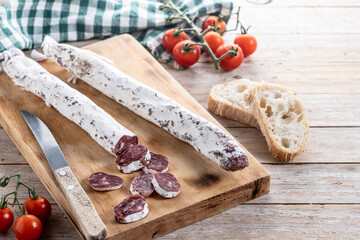 Fuet.Dry cured fuet sausage on wooden table. Copy space