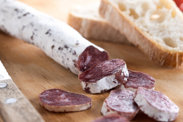 Fuet.Dry cured fuet sausage on wooden table. 