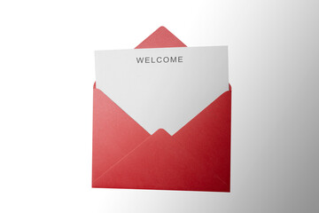 Top view of red envelope and postcard with white card with words Welcome on it. Welcome greeting for invitation, express hospitality, greet, show acceptance