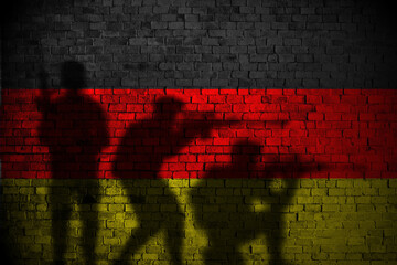 german flag on brick wall and soldiers shadow