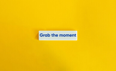 Grab the Moment Phrase. Concept of Taking Full Advantage of an Opportunity. Blue Text on Letter Tiles on Yellow Background. Minimal Aesthetic.