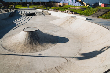 A talented skateboarder is performing an impressive trick on a ramp at a lively skate park, showcasing their skills and attracting the attention of onlookers who admire the scene