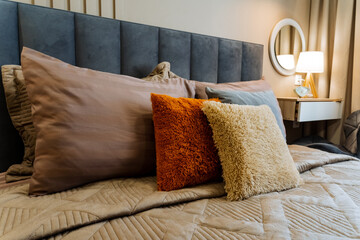 In a wonderfully cozy and inviting bedroom, there is a beautifully made bed that is adorned with...