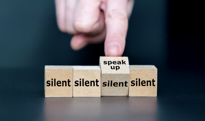 Hand turns cube and changes the expression 'silent' to 'speak up'.