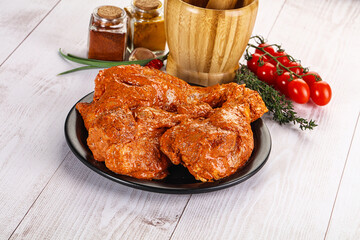 Raw turkey shoulder wing in Indian tandoori marinade
