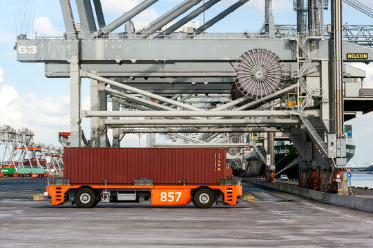 VDL Automated guided vehicle transporting a shipping container to a ship in the Port of Rotterdam