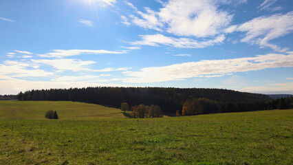 Fototapeta premium Weite Sicht auf herbstliche Bergwiesen und bewaldete Hügel im Thüringer Wald bei Neuhaus am Rennweg, idyllisches Tal im Schiefergebirge, Landkreis Sonneberg, Thüringen, Deutschland, Wandern im Herbst