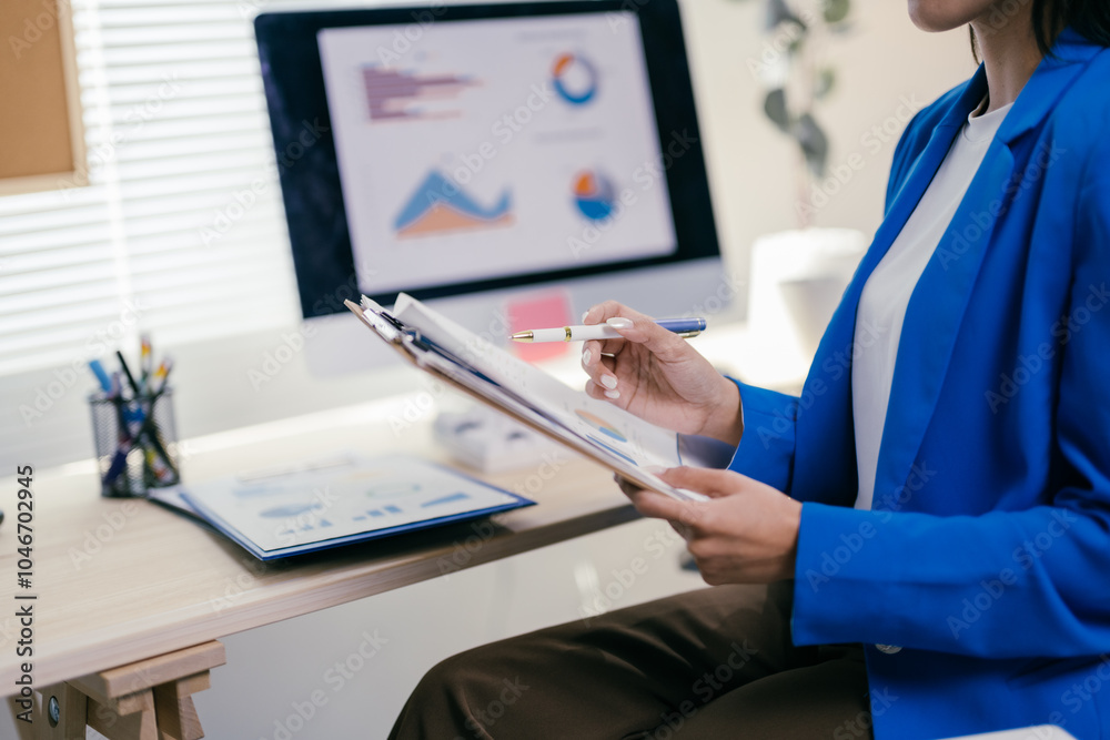 Poster focused businesswoman analyzing charts and graphs in modern office, strategizing for success. dedica