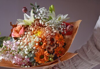 A woman holds a beautiful bouquet in her hand. A floral compliment.