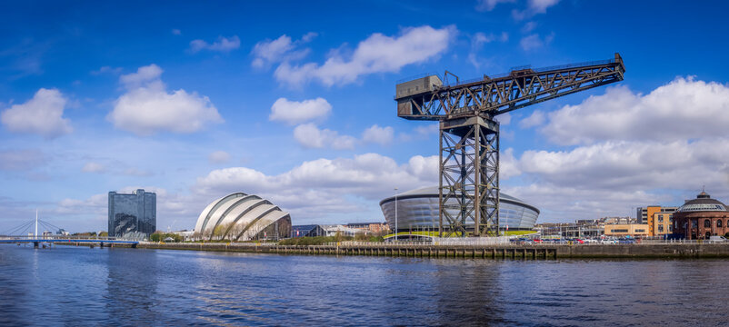 Glasgow, UK-April 19, 2016:Panorama of the North Bank of the River Clyde, showing an old shipyard crane, rotunda and modern buildings