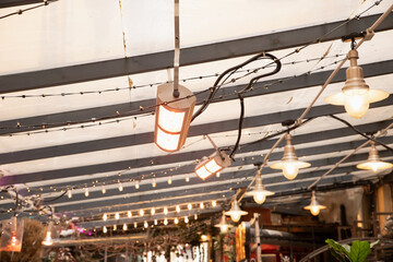 infrared lamp, infrared heater or IR lamps. Soft warm lights illuminate an outdoor dining area...
