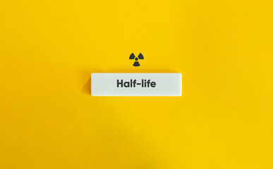 Half-life or Half-time Term. Radioactivity Sign and Text on Block Letter Tile on Yellow Background....