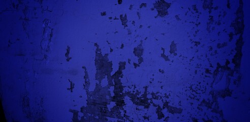 long background of cracked wall blue color. blue wall texture background marked by long exposure to the elements outdoors and painting peeling off.