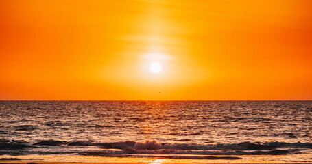 Natural Color Sunset Sunrise Sky Over Sea. Seascape With Shining Setting Sun On Sea Horizon