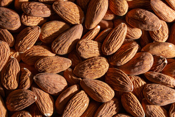 Fototapeta premium Scattered Almonds. Background from Almond Nuts. Natural High-Calorie Snacks