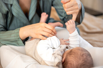 A mother plays with a newborn baby. Newborn baby.