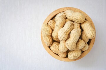 Roasted Peanuts in wooden bowl on white background