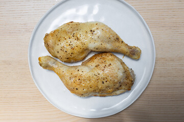 A plate of two grilled chicken legs.