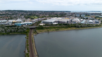 Obraz premium aerial photograph of holes Bay in Poole Harbour showing the railway line on a causeway and industrial units in background