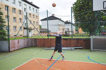 Volleyball player is passing on a hard court during an outdoor practice session. The action captures focus, movement, and ball control in a casual game setting