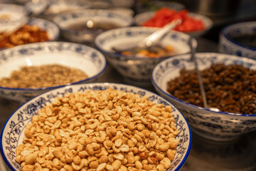 A Colorful Display of Nuts and Condiments in Traditional Bowls
