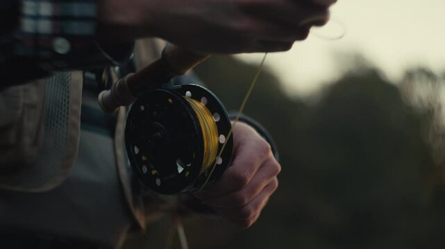 Young fly fisherman casting on a foggy river at sunrise