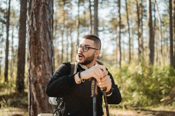 Young caucasian man drinking water taking break from hiking or trekking