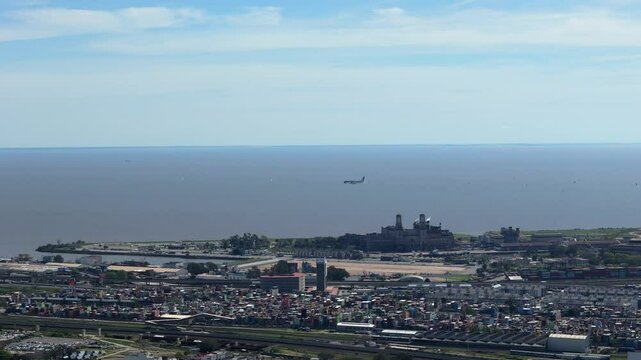 Far shot of an airplane landing on Aeroparque - Buenos Aires with the river in the background, sunny, copy space