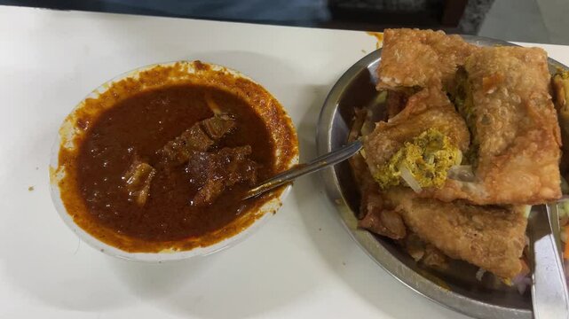 Close up shot of Mughlai paratha and mutton kossa served in a Bengali restaurant.