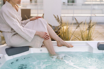 Unrecognizable woman relaxing in the hot tub outdoors