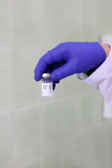 The doctor holds an ampoule with diphtheria and tetanus vaccine in his hand.