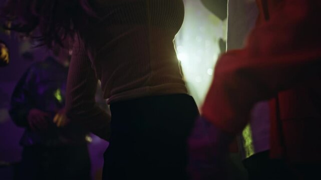 Passionate clubbers dancing club neon lights closeup. Unknown couple dance moves