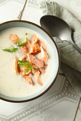 blue bowl with celery root, leek and fennel soup with salmon on light table
