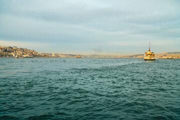 Ferries moving on the wavy sea in the Bosphorus. Buildings in the background. Sea traffic.