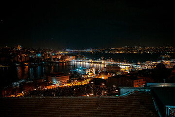 Fototapeta premium Night view of the Golden Horn Bridge. July 15 Martyrs Bridge in the background. Photo taken from a high area. Galata Tower. Wide angle view of Istanbul.