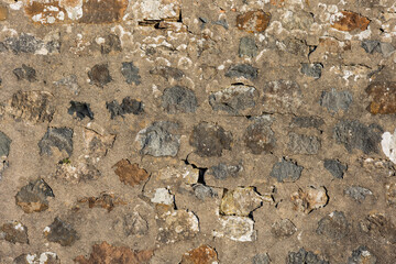 Old stone wall texture with weathered sandstone blocks with cement mortar