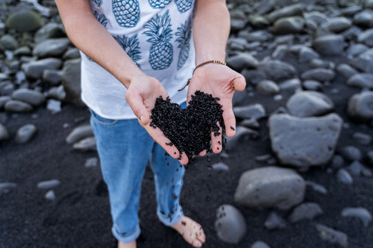 Chico cogiendo Arena negra en Lanzarote, en las Salinas de Janubio. (Canarias)