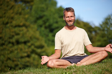 Obraz premium Yoga, portrait and man with lotus outdoor for exercise, meditation and chakra for holistic fitness. Mature, happy yogi and pose for health, body wellness and relax for mindfulness or peace in USA