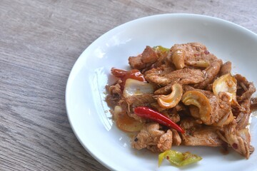 fried slice chicken meat with cashew nut and red chili on plate 