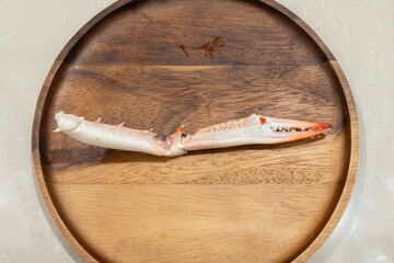 Steamed crab claws placed on a wooden tray