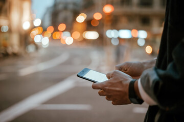Close-up of male hands with smartphone outdoors