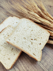 Square pieces of white toast bread and ears of dry wheat
