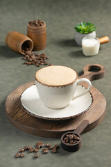 Raf Coffee: A creamy, frothy cup of Raf coffee served in a rustic ceramic mug on a wooden board. Surrounding the cup are scattered coffee beans