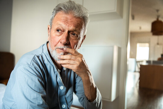 Elderly man deep in thought sitting at home