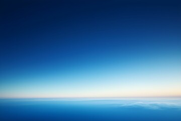 Fototapeta premium Expansive blue sky and ocean horizon during twilight hours