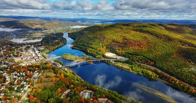 Mirror surface of the blue river reflecting clouds in the sky. Beautiful panorama of Vermont, New England, USA. Overcast sky above the scenery. Aerial perspective.