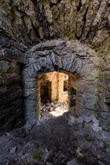 Obraz premium Ancient Stone Archway Leading to a Dimly Lit Passageway